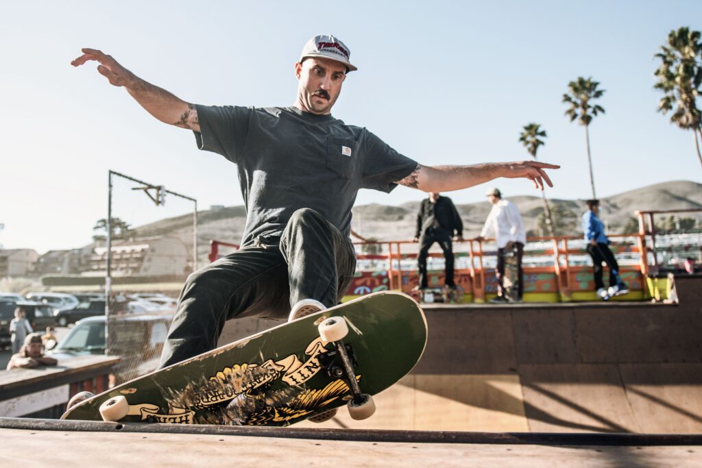 Skater på skateboard i en bowl i en udendørs skatepark