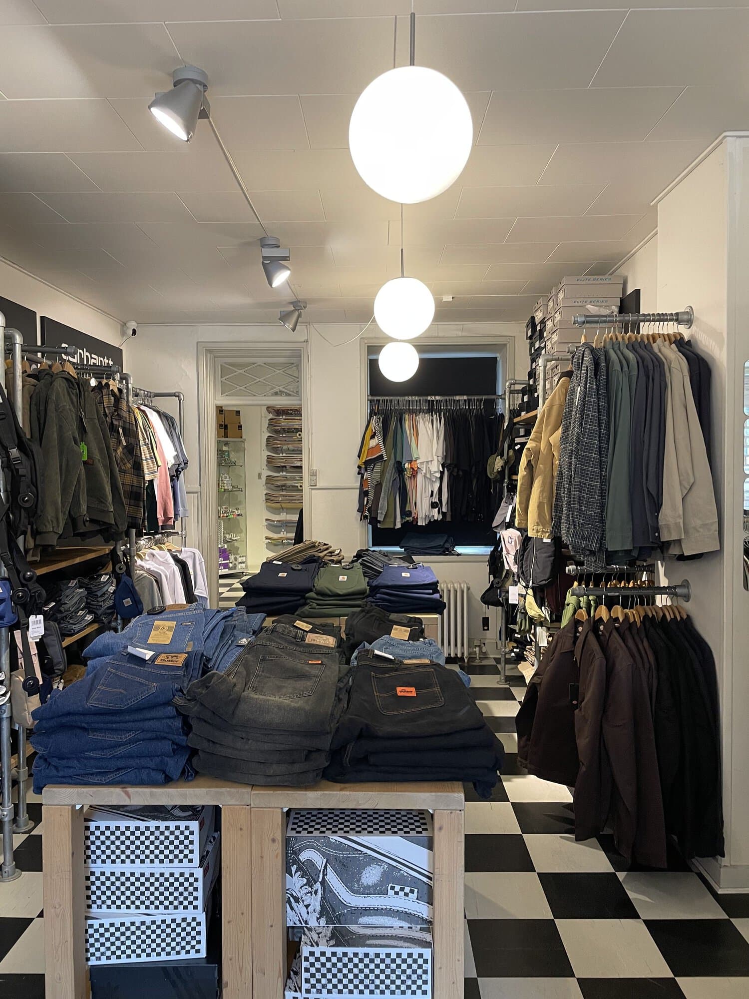 Foldede jeans og tøj på stativer i Skate House