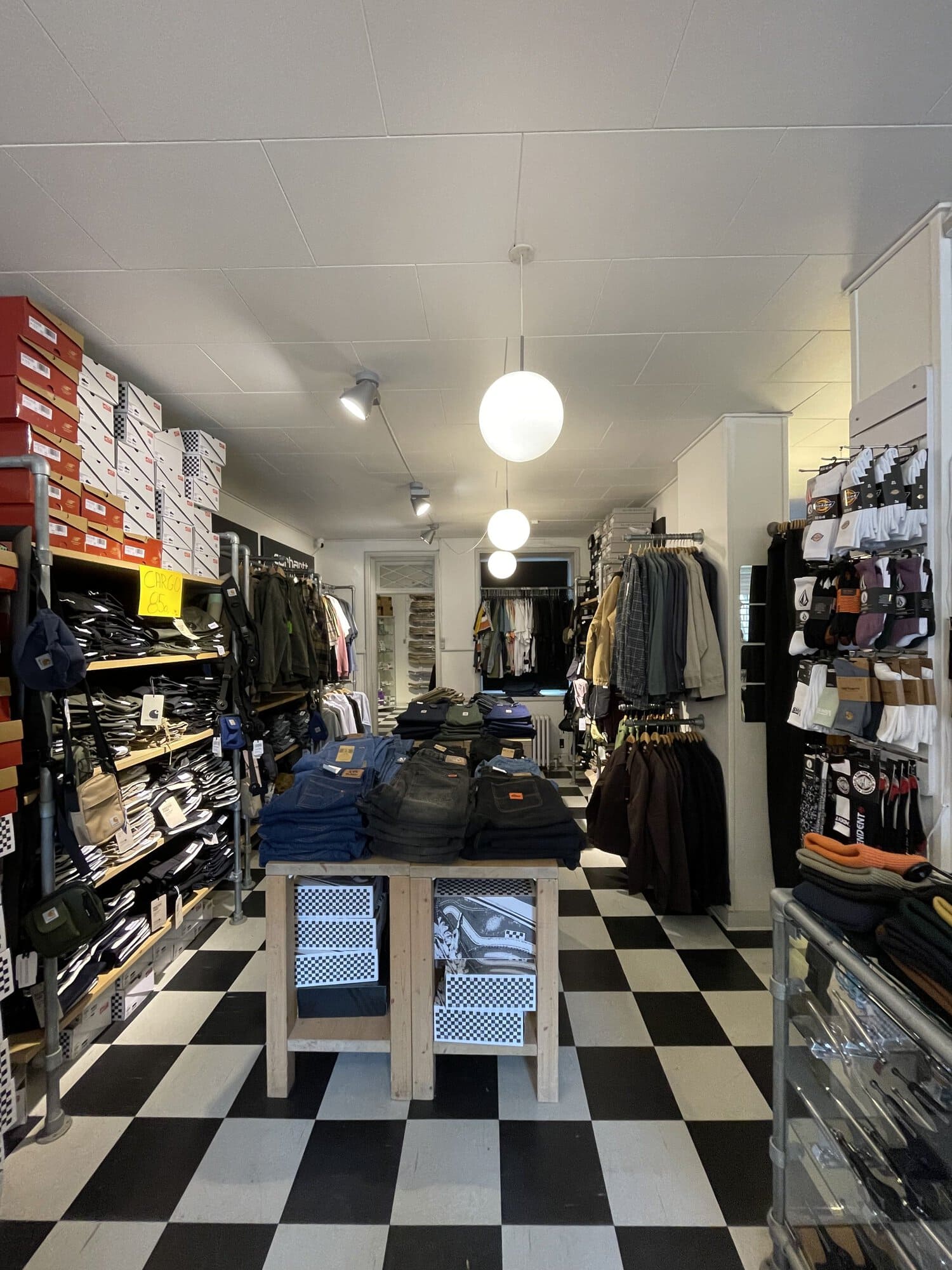 Tøjhylder, bukser og strømper langs gangen i Skate House