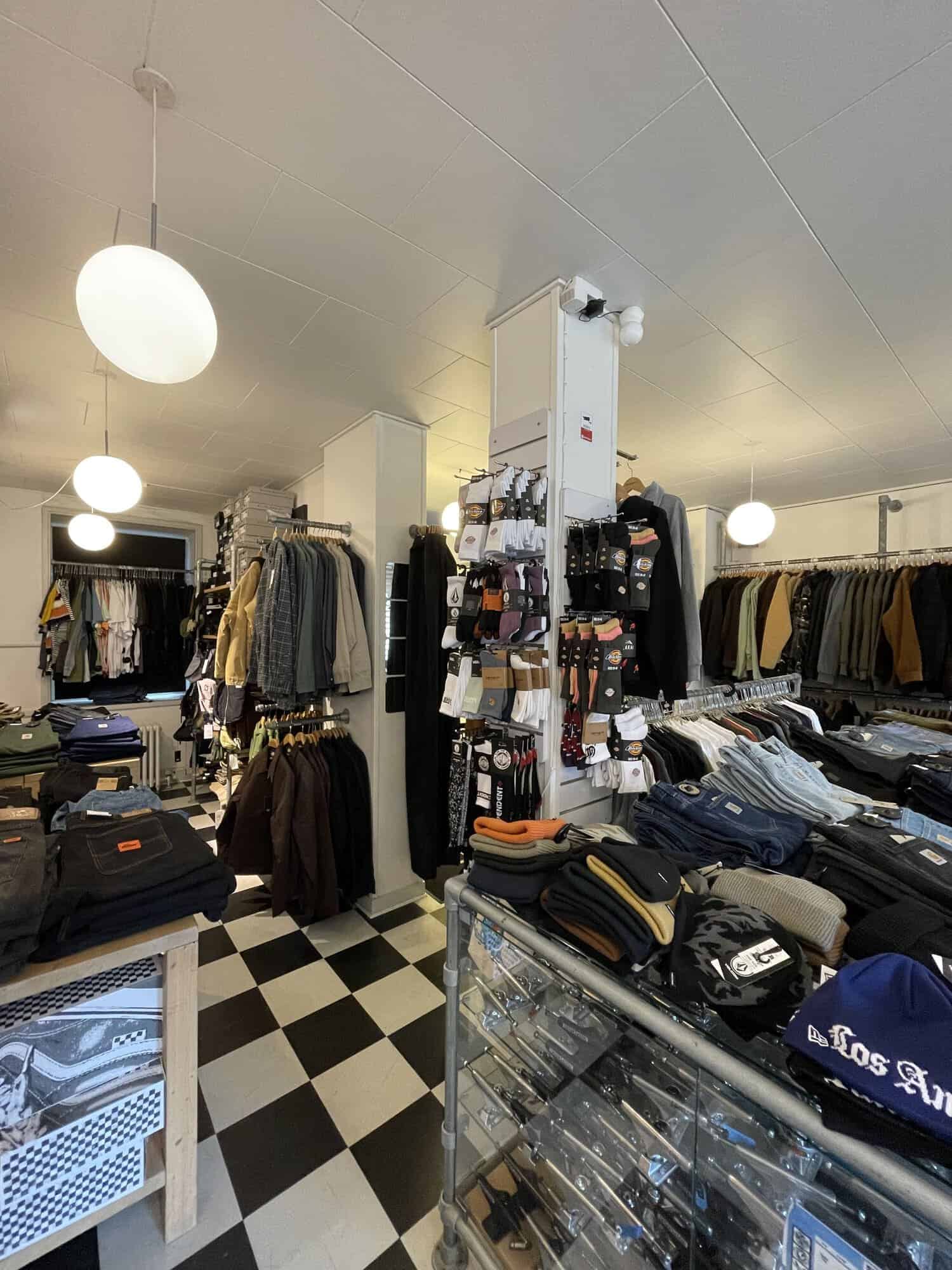 Strømper, huer og bukser ved glasmontre i Skate House