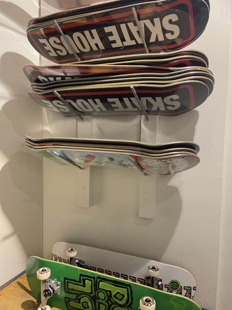 Skateboard decks på væghylder i Skate House